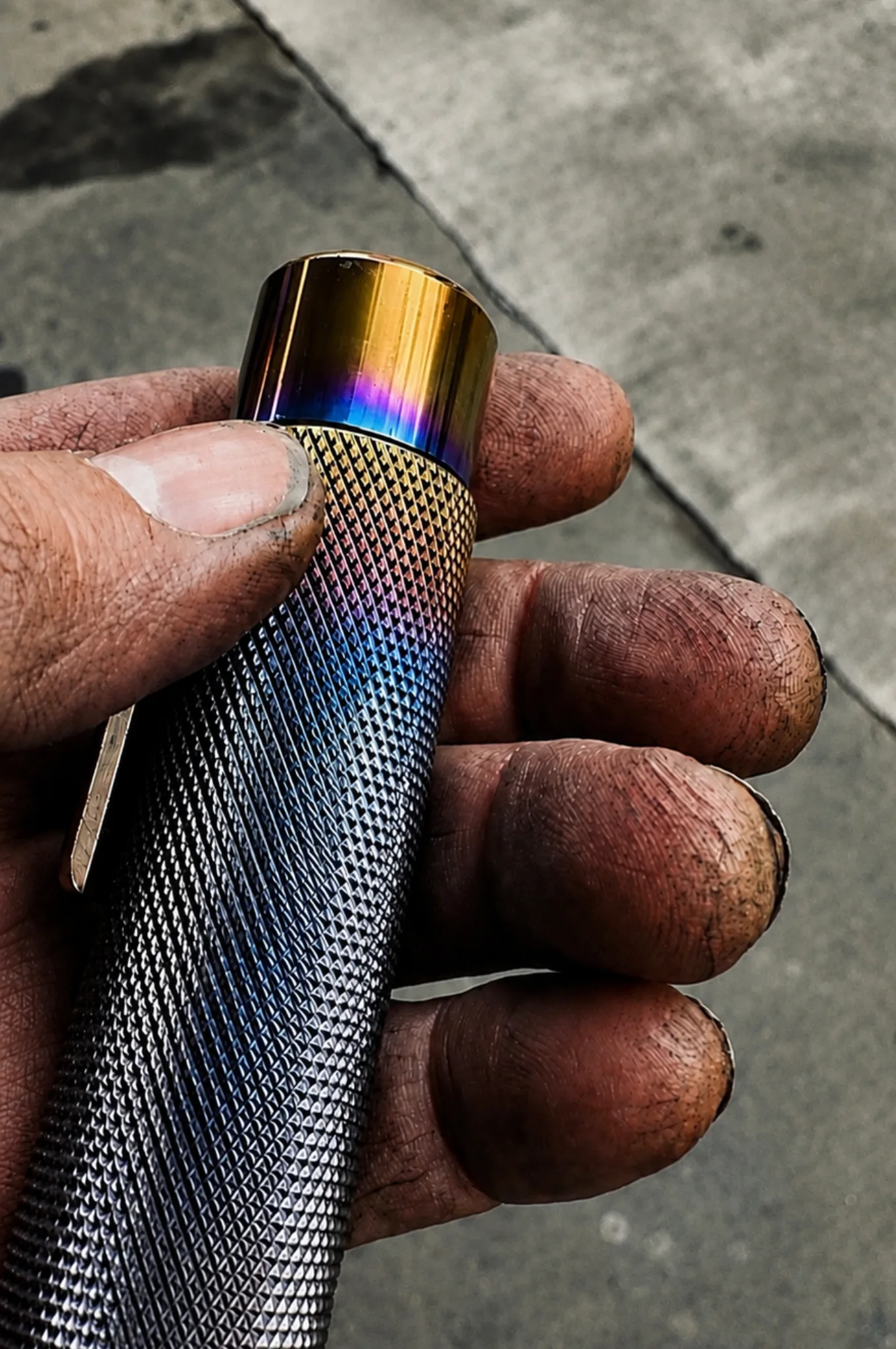 Næxon stainless steel tungsten holder with blue and gold heat coloring held by a welder